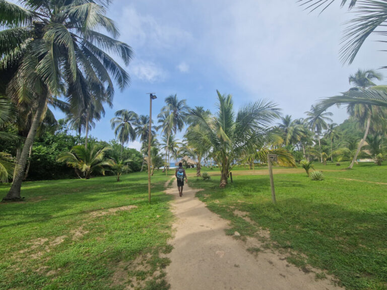 Man walking toward Playa Brava in Tayrona National Park, part of the Colombia travel itinerary for three weeks